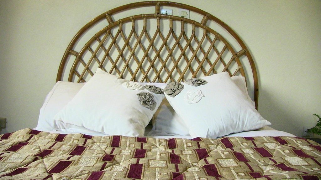 Chambre avec tête de lit en rotin à Seme Beach Hotel